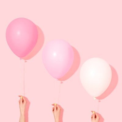 Zero Waste 1st Birthday Party Ideas 2025 Three hands holding pink balloons